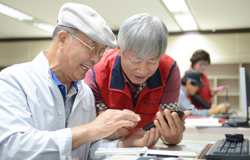 대전 서구가 지난 2014년 9월 구청 전산교육장에서 개설한 노인 대상 스마트폰 활용강좌에 참여한 한 노인수강생이 스마트폰을 조작하며 웃고 있다  